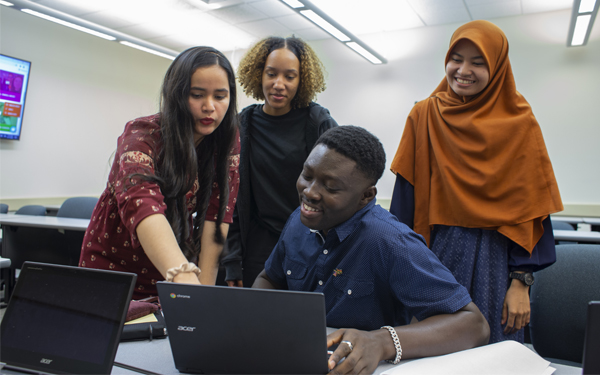 Students looking at laptop