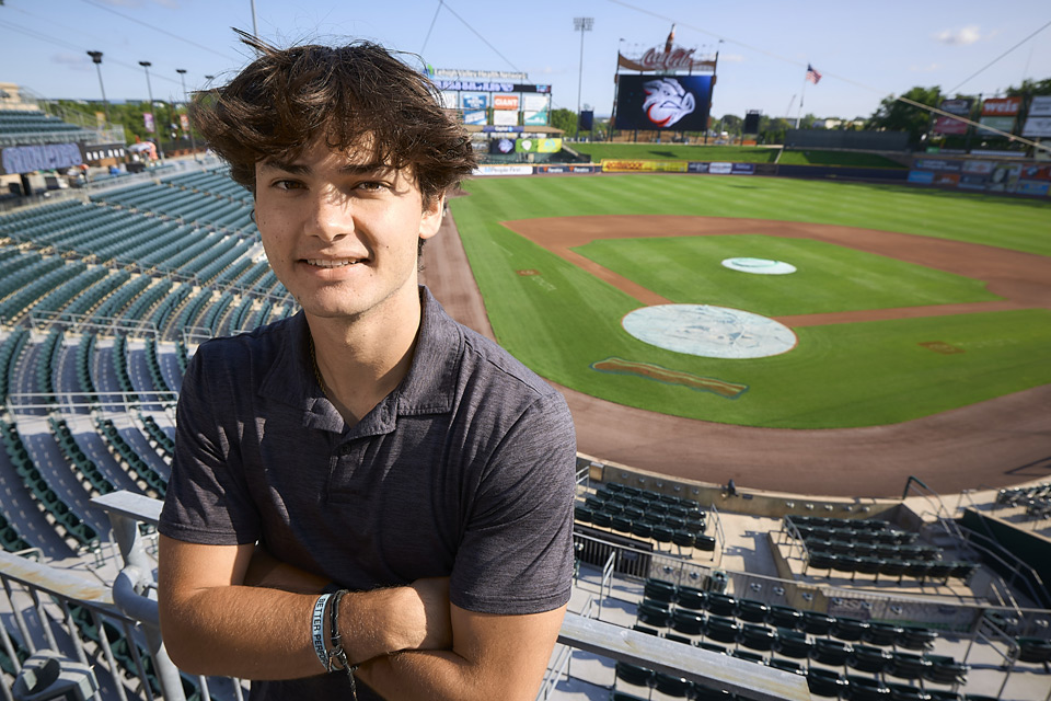Male NCC alum standing in the Iron Pigs stadium