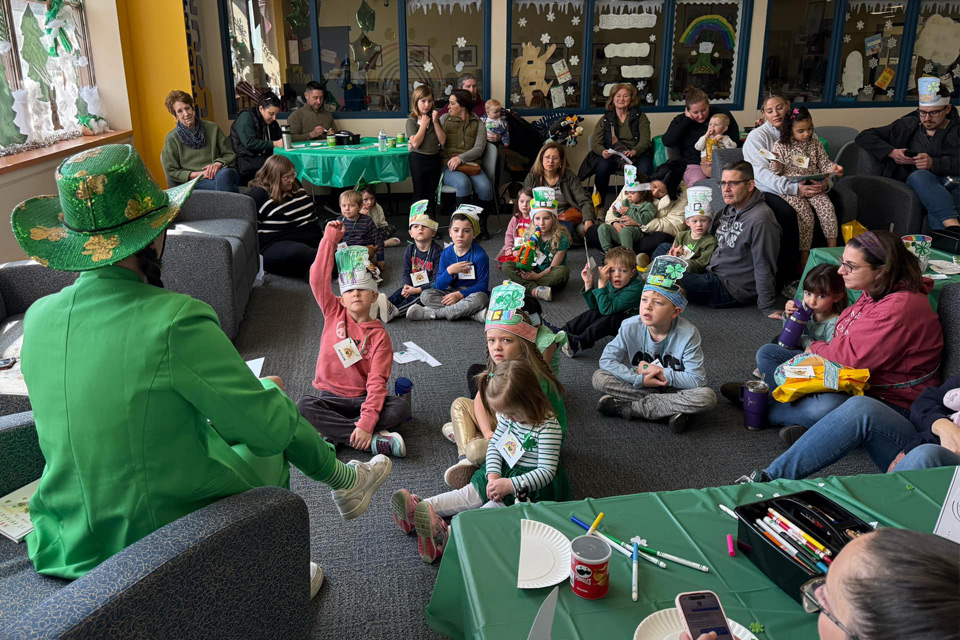 Kids sitting on the floor listening to someone read to them