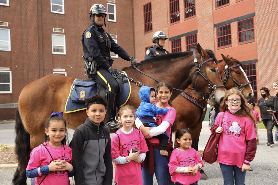 Kids standing in front of a mounted police officer