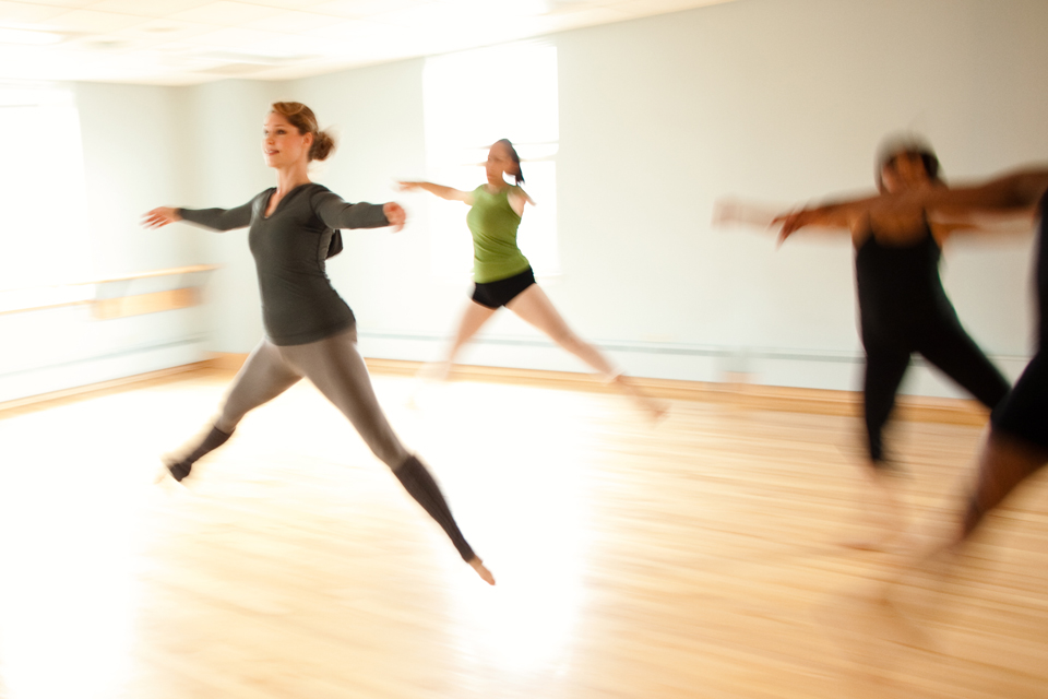 dancers mid-leap in a dance studio