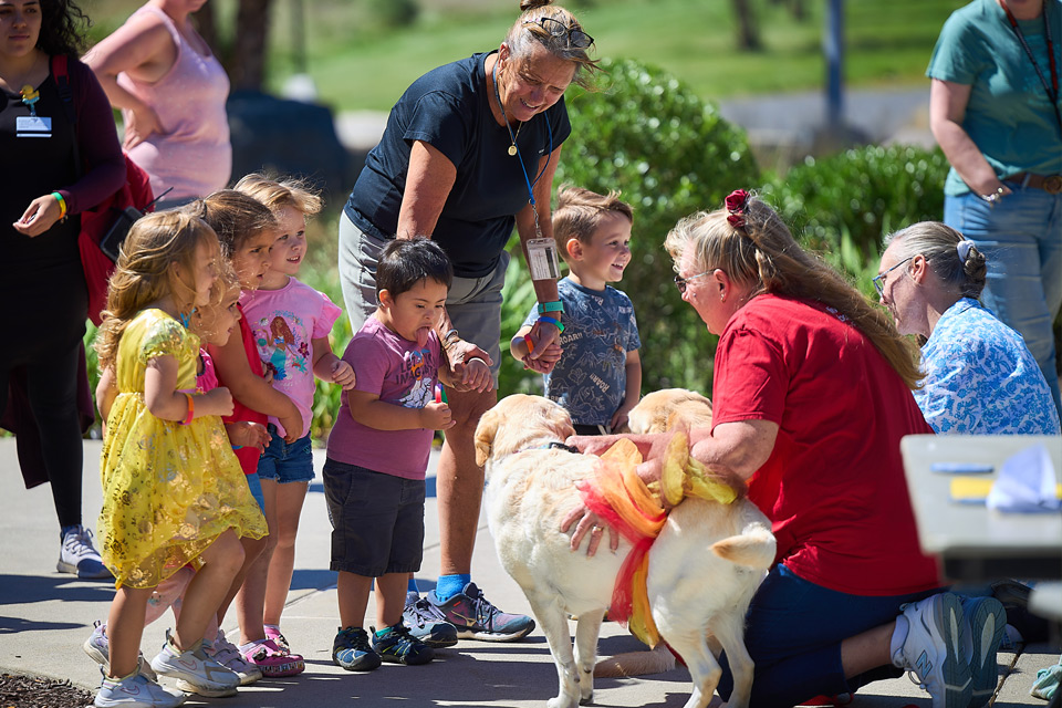 children petting puppies at the monroe campus